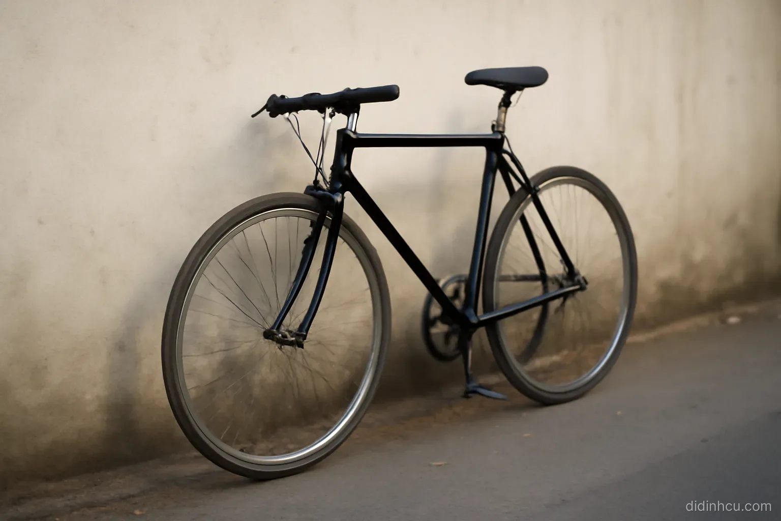 a bicycle leaning against a wall with one wheel worn smooth and the other newer looking